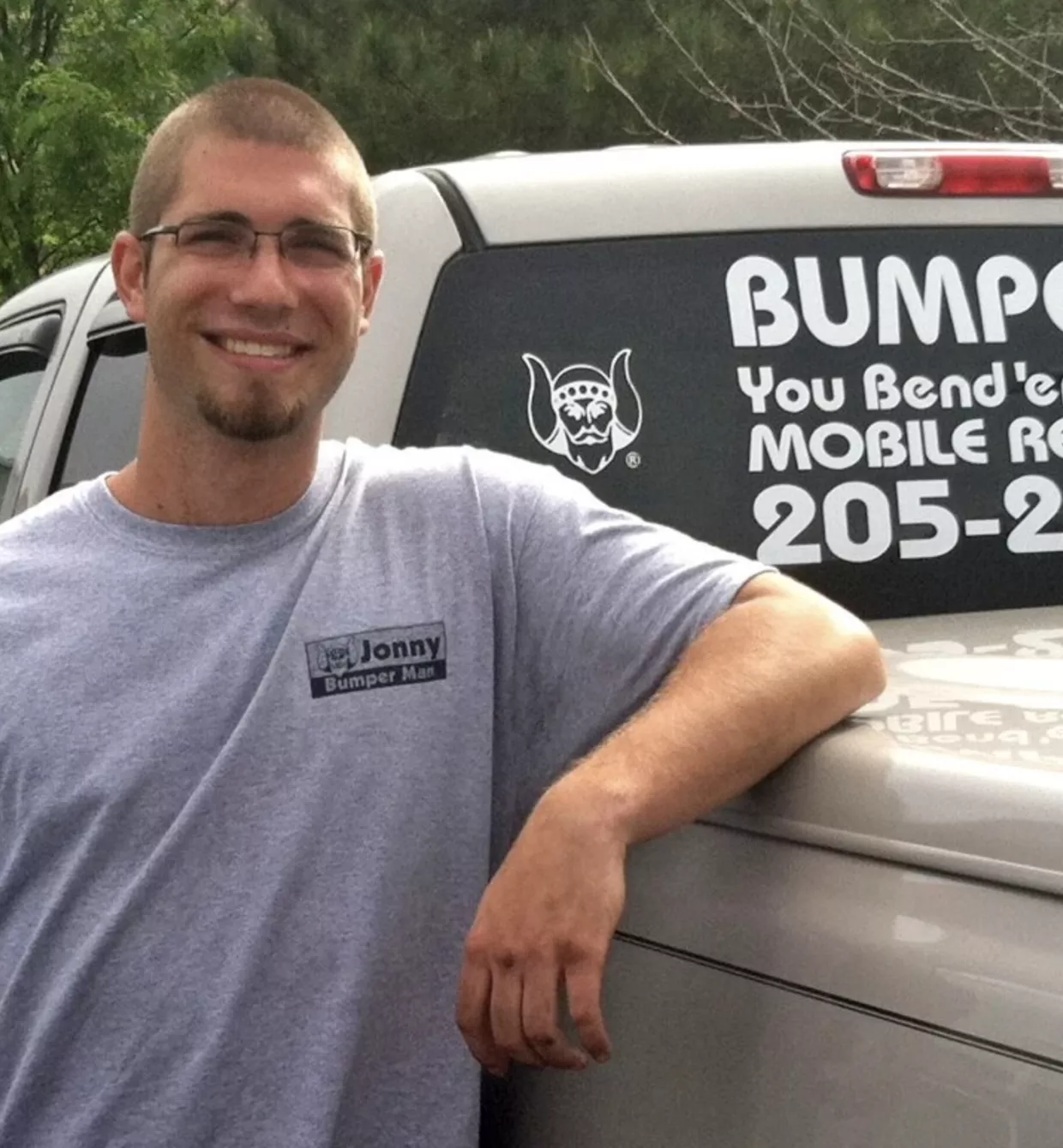 a man standing next to a truck with a sign on it