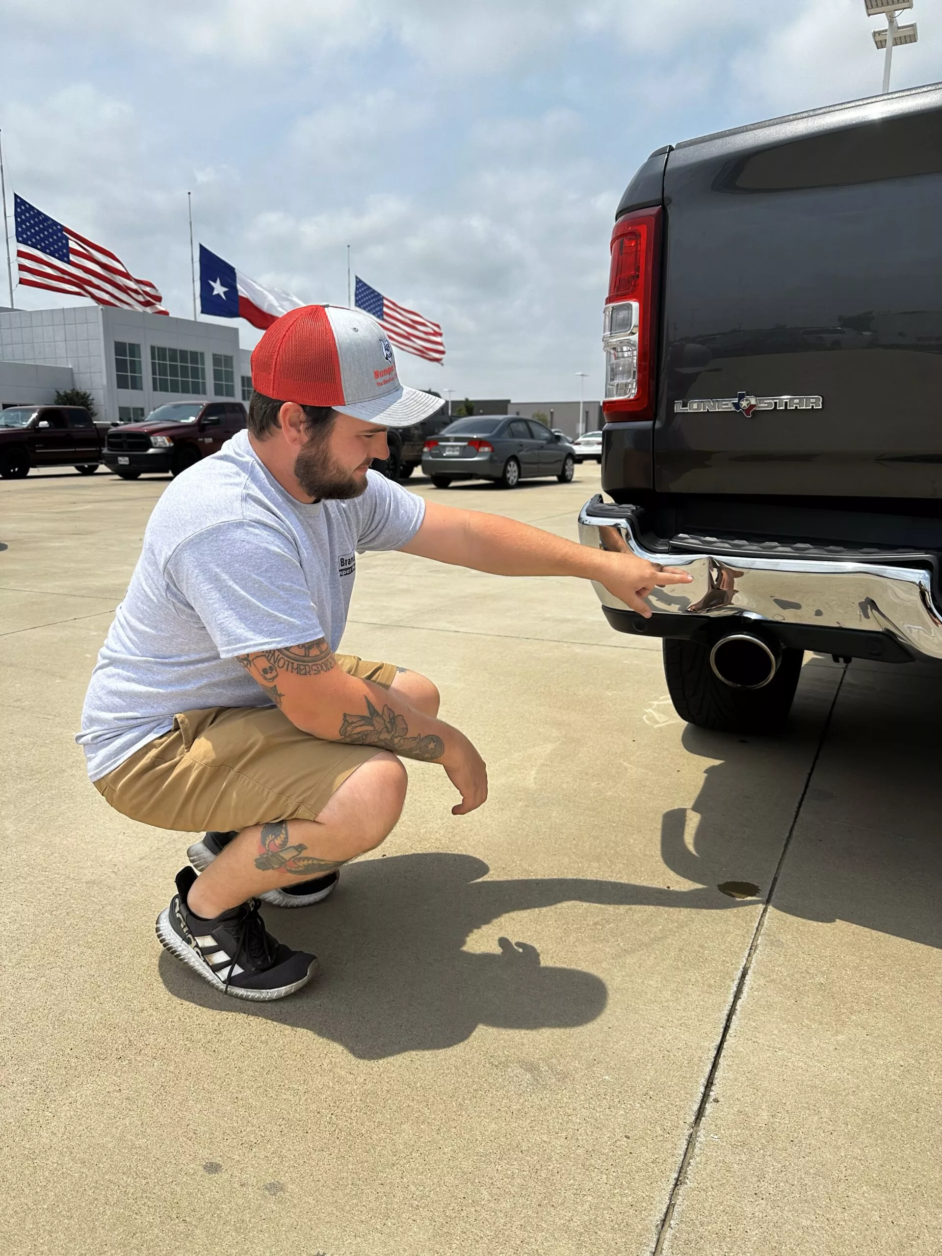 a man kneeling down next to a black truck